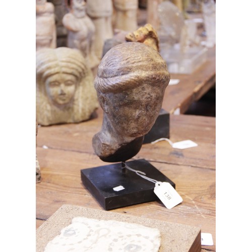 138 - A marble female head, features worn, her hair held in place beneath a fillet, 20cm high (at fault) 
... 