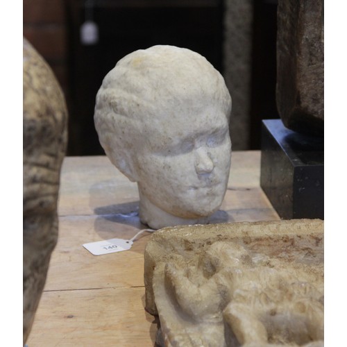 140 - A Roman style head of a young woman, with worn features, her hair drawn back into a tight plaited bu... 