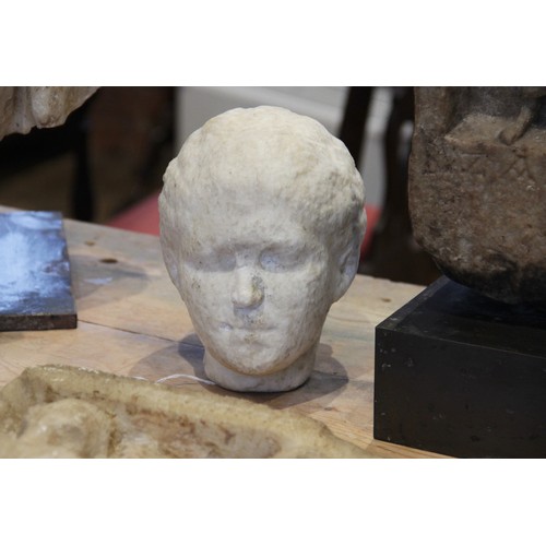 140 - A Roman style head of a young woman, with worn features, her hair drawn back into a tight plaited bu... 