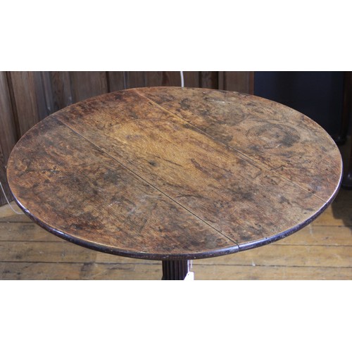 582 - A George III tripod table, the circular oak three plank top, raised upon an associated fluted column... 