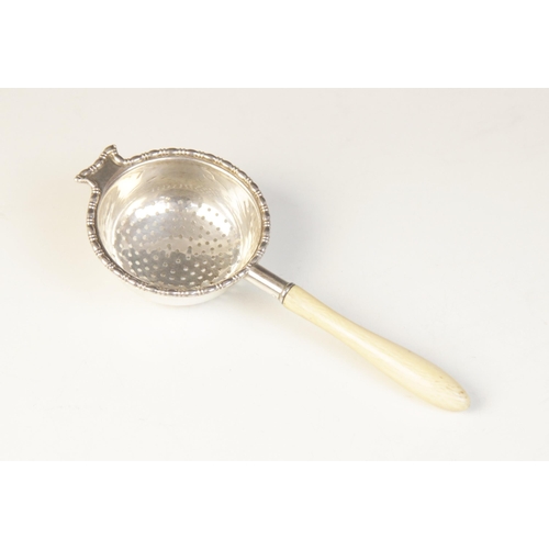 102 - A George V silver and ivory tea strainer, Mappin & Webb, Birmingham 1925, the pierced circular bowl ... 