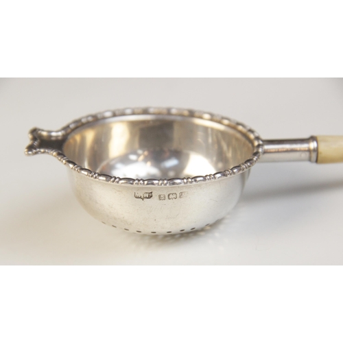 102 - A George V silver and ivory tea strainer, Mappin & Webb, Birmingham 1925, the pierced circular bowl ... 