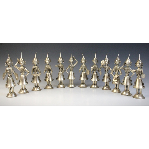 121 - A set of twelve silver coloured Indian musician figures, each in traditional dress adorned with bell... 