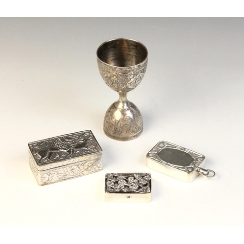13 - An Indian silver coloured double-ended spirit measure, of typical form with scrolling foliate panel ... 