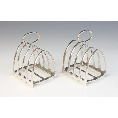 19 - A pair of silver four division toast racks, Garrard & Co, 1957, comprising five arched bars with sim... 