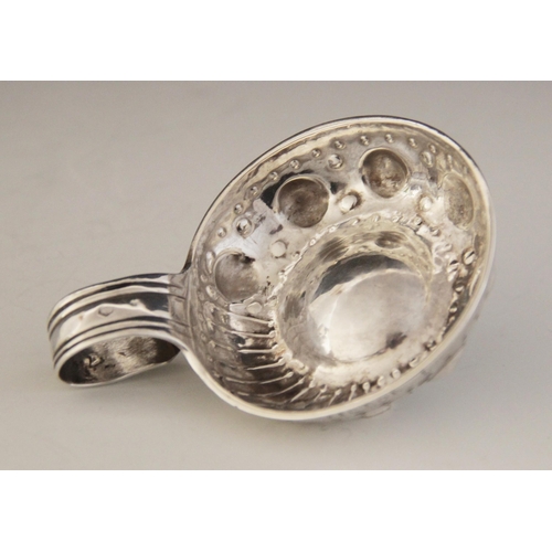 27 - A continental silver wine taster, of circular form with embossed and engraved decoration and loop ha... 