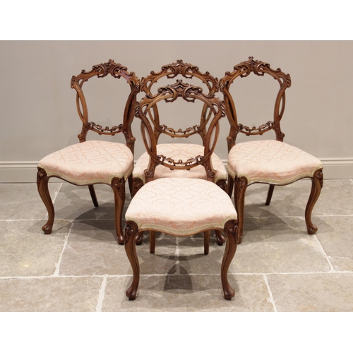 702 - A set of four Victorian walnut balloon back salon/dining chairs, each chair with an openwork ring ba... 