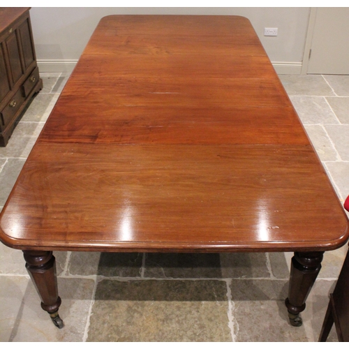 714 - A Victorian mahogany extending dining table, the rectangular top with rounded corners and a moulded ... 