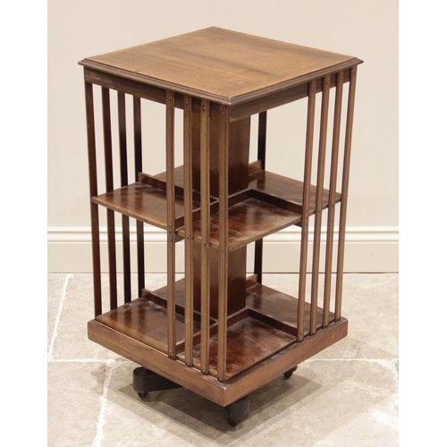 725 - An Edwardian mahogany revolving bookcase, the square top inlaid with satinwood banding, over two tie... 