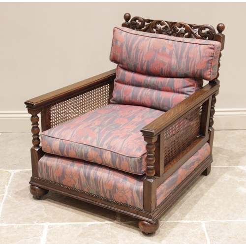 726 - An early 20th century oak bergere armchair, later re-covered in Liberty style fabric, the scrolling ... 