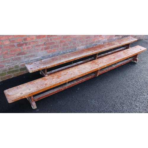 744 - A pair of mid century stained wooden school gym benches, each raised on three trestle type supports,... 