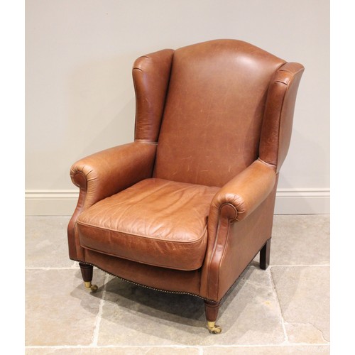 743 - A tan leather armchair, by Laura Ashley, late 20th century, the padded wing backs extending to scrol... 