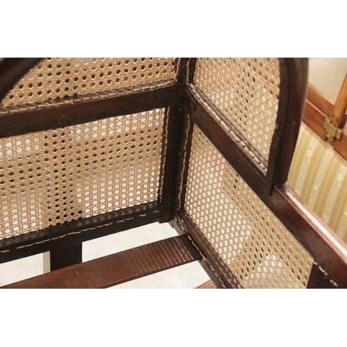 709 - A Victorian mahogany and rattan cradle, the ogee shaped canopy with turned finials above rattan side... 