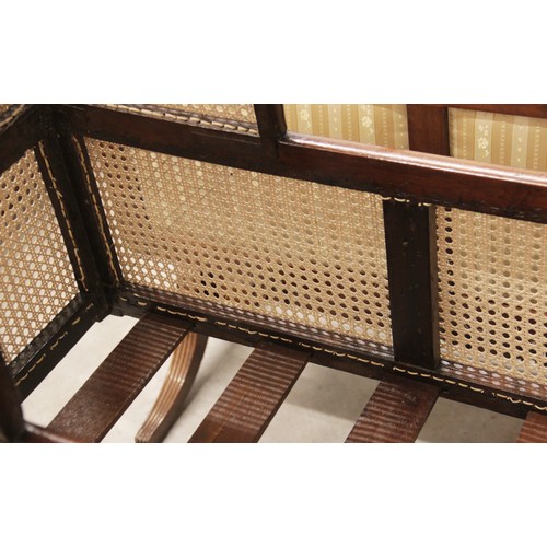 709 - A Victorian mahogany and rattan cradle, the ogee shaped canopy with turned finials above rattan side... 