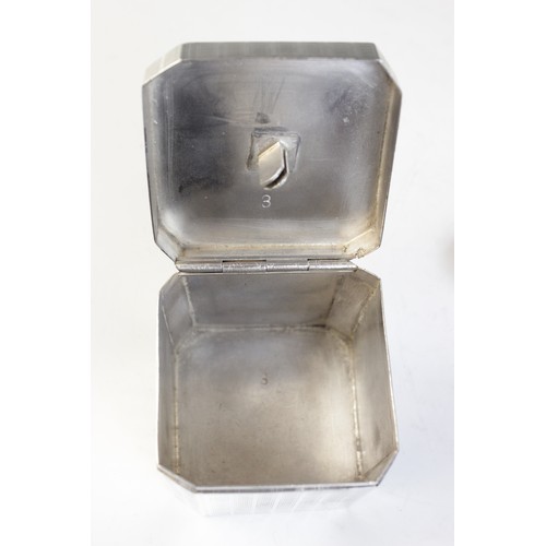 26 - An Art Deco tea caddy, of faceted form with engine turned decoration, opening to reveal integral cad... 