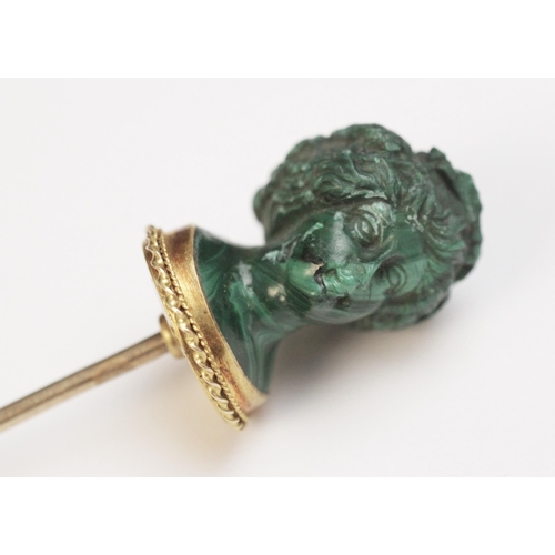 116 - A malachite stick pin, carved in the classical style as a female head with waved hair and a crown of... 