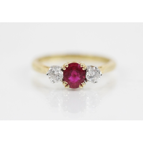 130 - A ruby and diamond three stone ring, the central oval mixed cut ruby (untested) measuring 5.6mm L x ... 