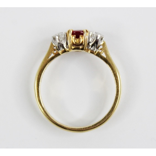 130 - A ruby and diamond three stone ring, the central oval mixed cut ruby (untested) measuring 5.6mm L x ... 