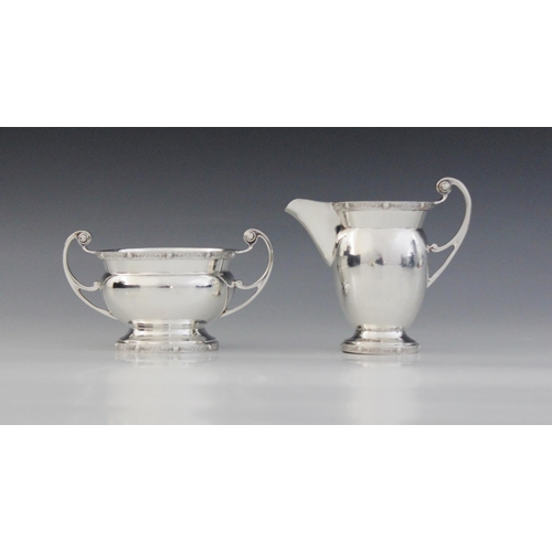 19 - A George VI silver milk jug and sucrier, Charles S Green & Co Ltd, Birmingham 1938, each of plain po... 