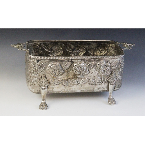 54 - A late 19th silver coloured jardinière, of rectangular form with cast twin-handles, embossed floral ... 