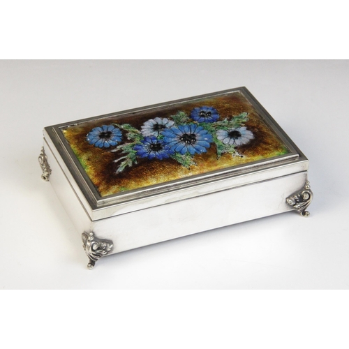 55 - A silver coloured enamelled jewellery casket, of rectangular form raised on four scrolling feet, the... 