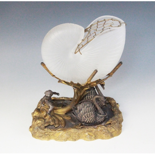 56 - A silver plated and gilded nautilus shell centre piece, 19th century, modelled as a putto and two sw... 