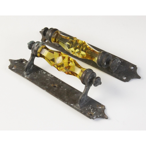 587 - A pair of faceted amber glass door pull handles, 19th century, the glass handles set to ogee brass m... 