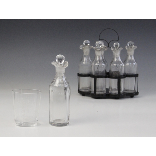 590 - A six bottle cruet set, each clear glass double lipped bottle with associated stopper, and engraved ... 