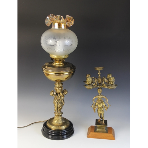 640 - A Victorian figural brass oil lamp, later converted, the associated amber glass and etched shade abo... 