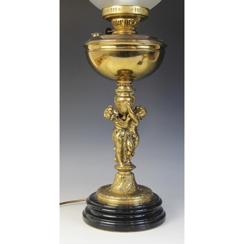 640 - A Victorian figural brass oil lamp, later converted, the associated amber glass and etched shade abo... 