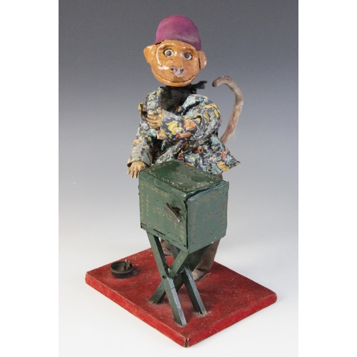 641 - A scratch built clockwork automaton modelled as a monkey winding an organ, the Papier Mache head wit... 