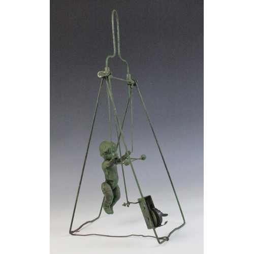 673 - A celluloid and wire spring driven trapeze toy, 33.5cm high (at fault)