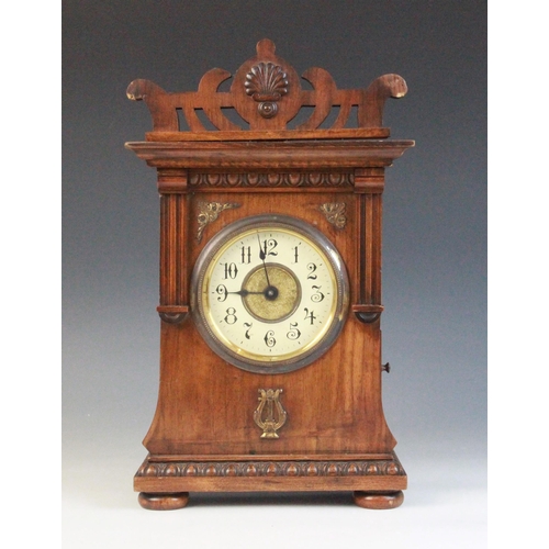 688 - A late 19th/early 20th walnut cased German musical bracket clock, the openwork pediment above an arc... 