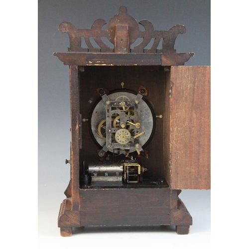 688 - A late 19th/early 20th walnut cased German musical bracket clock, the openwork pediment above an arc... 