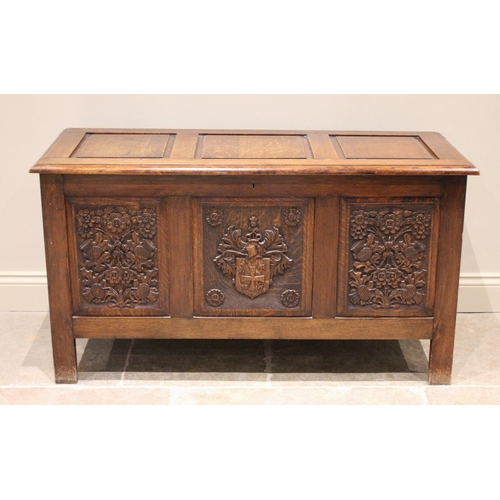 702 - A 17th century style oak coffer, mid 20th century, the three panel hinged top over a central panel c... 