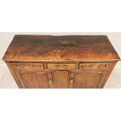 709 - An 18th century oak dresser base, the moulded plank top above three oak lined drawers and a pair of ... 