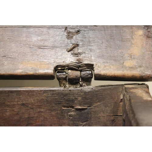 713 - A 17th century oak six plank coffer bach, the channelled and serrated hinged cover applied with an i... 