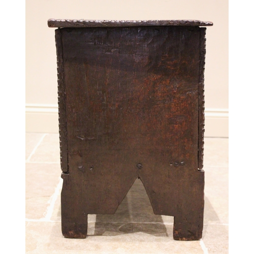 713 - A 17th century oak six plank coffer bach, the channelled and serrated hinged cover applied with an i... 