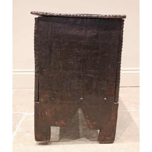 713 - A 17th century oak six plank coffer bach, the channelled and serrated hinged cover applied with an i... 