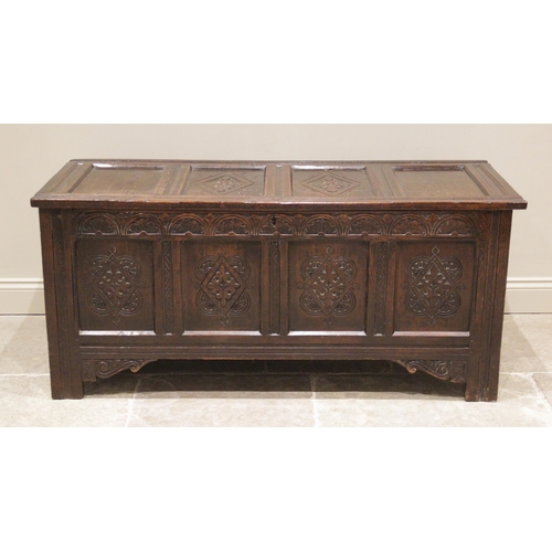 714 - A large 18th century carved oak coffer, with a four panel hinged cover, the two central panels carve... 