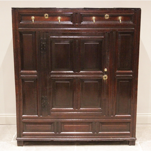 718 - An 18th century oak panelled hall/livery cupboard, formed as a central cupboard door below two drawe... 