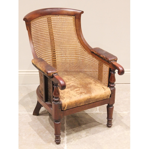 727 - A Regency mahogany bergère library chair, the curved back extending to the down swept padded arms en... 