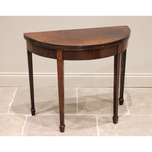 736 - A George III demi-lune mahogany folding tea table, the top with a channelled edge opening to a polis... 