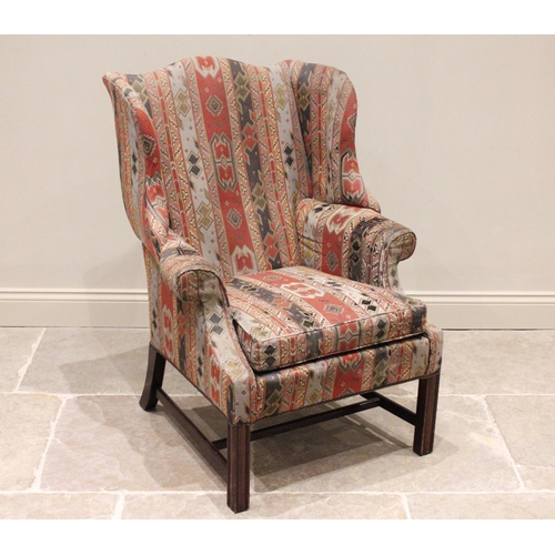 738 - A George III style wing back armchair, late 20th century, with shaped wing backs extending to padded... 