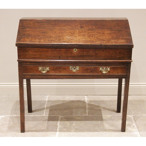 739 - A George III oak clerk’s desk, the hinged slope opening to two small drawers and a pigeon hole, abov... 