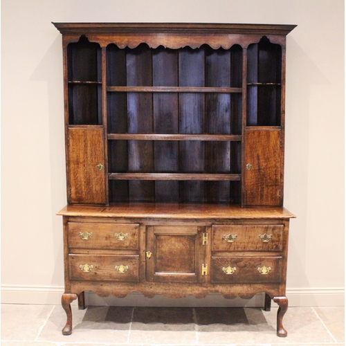 741 - A George III oak dresser, the enclosed plate rack with a moulded cornice over a shaped apron and thr... 