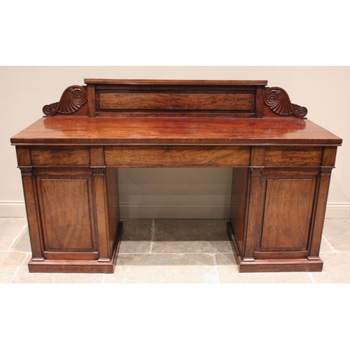 745 - A mid 19th century twin pedestal mahogany sideboard, the raised back board extending to scroll and b... 