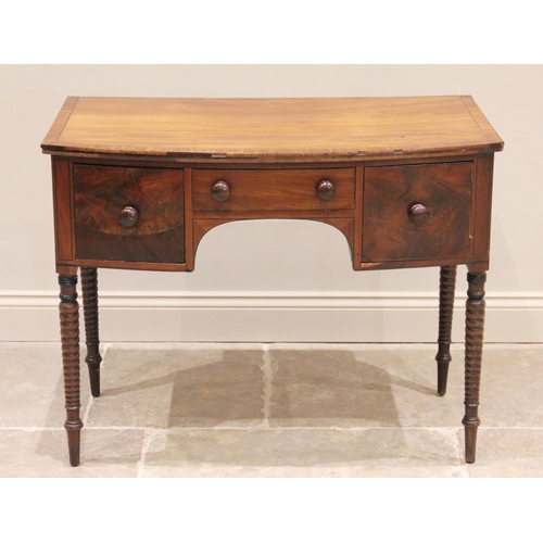 753 - An early 19th century mahogany bow front side table, the cross banded top above an arrangement of th... 