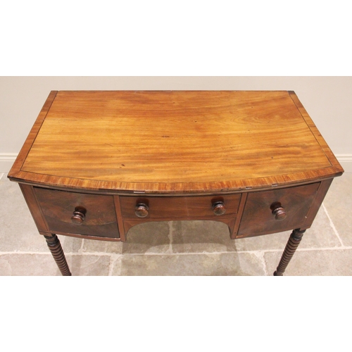 753 - An early 19th century mahogany bow front side table, the cross banded top above an arrangement of th... 