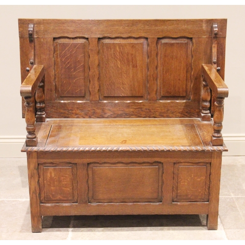 769 - An early 20th century medium oak monks bench, the three panel sliding back rest raised upon four bal... 